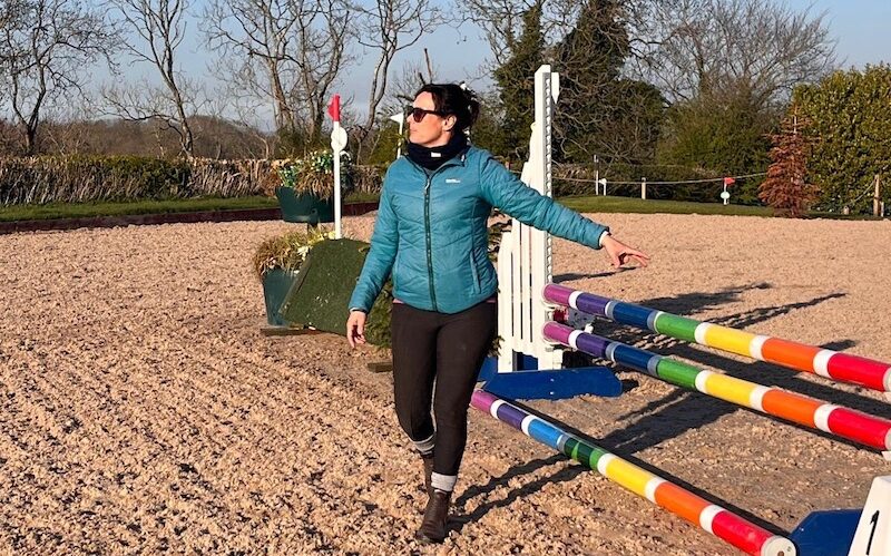Woman pointing at a horse jump